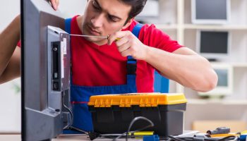 Professional repair engineer repairing broken tv